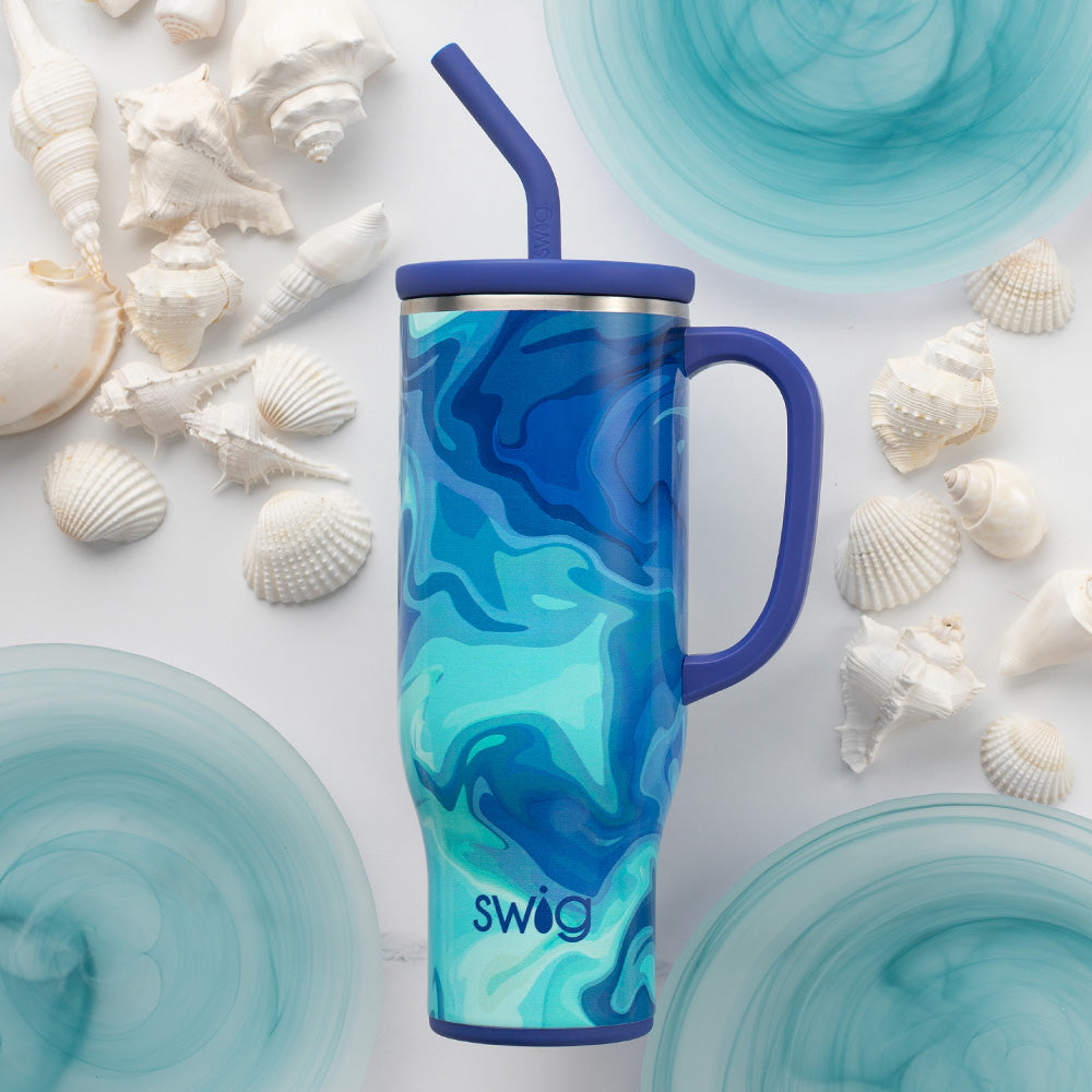 Swig Life Blue Lagoon 30oz Mega Mug shot against a light background with white seashells and blue accents
