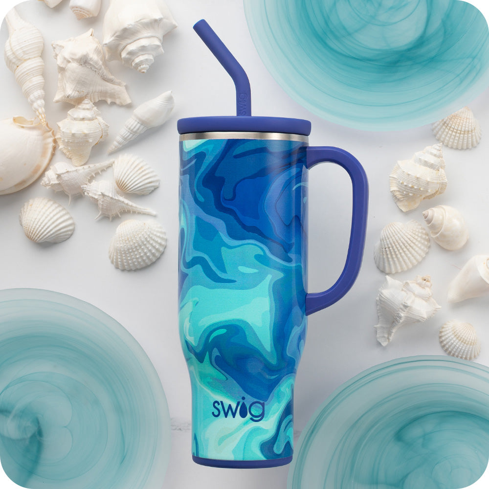 Swig Life Blue Lagoon 30oz Mega Mug shot against a light background with white seashells and blue accents
