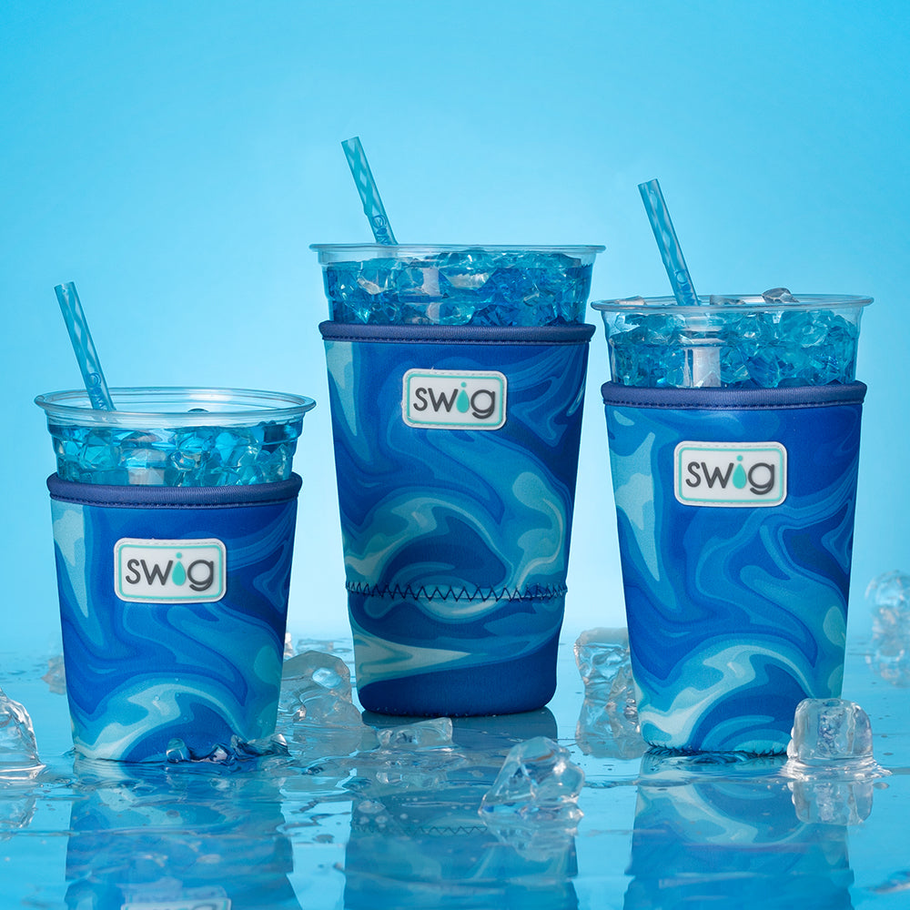 Swig Life Blue Lagoon Iced Cup Coolies shot together on a blue background with water and ice cubes
