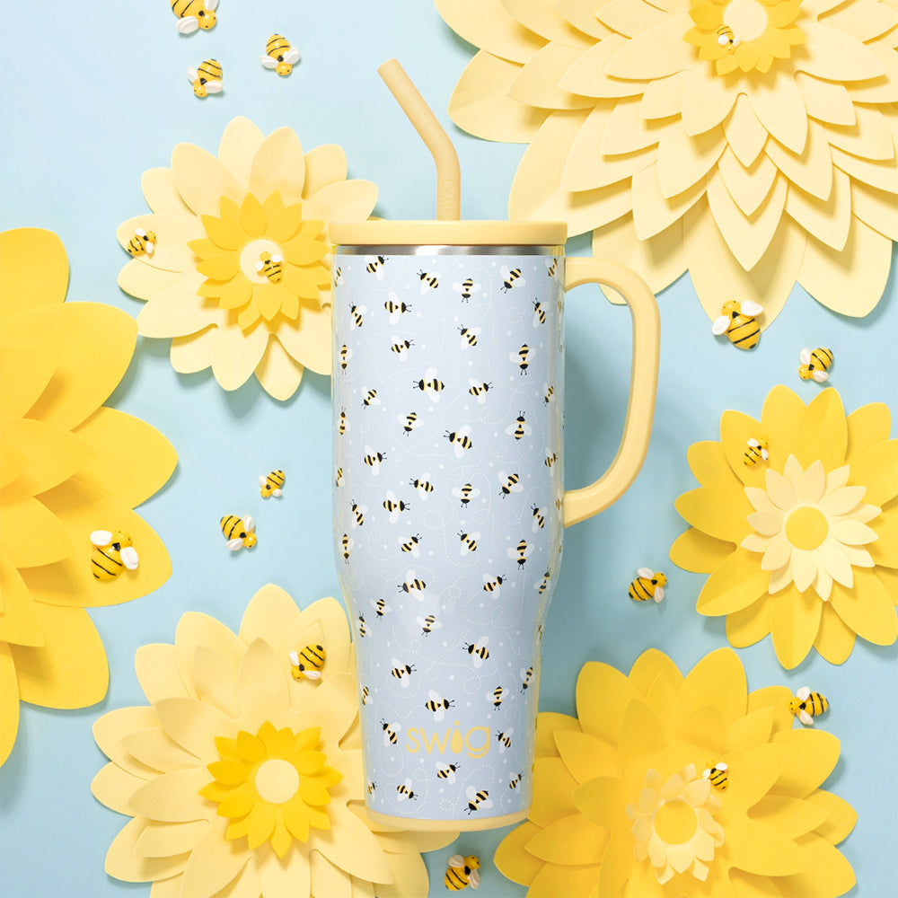 Swig Life Busy Bee 40oz Mega Mug with yellow flowers and yellow bees shot on a light blue background