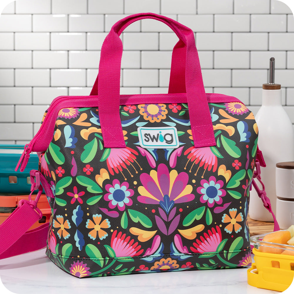 Swig Life Caliente Packi 12 Cooler with adjustable strap on a white tile background