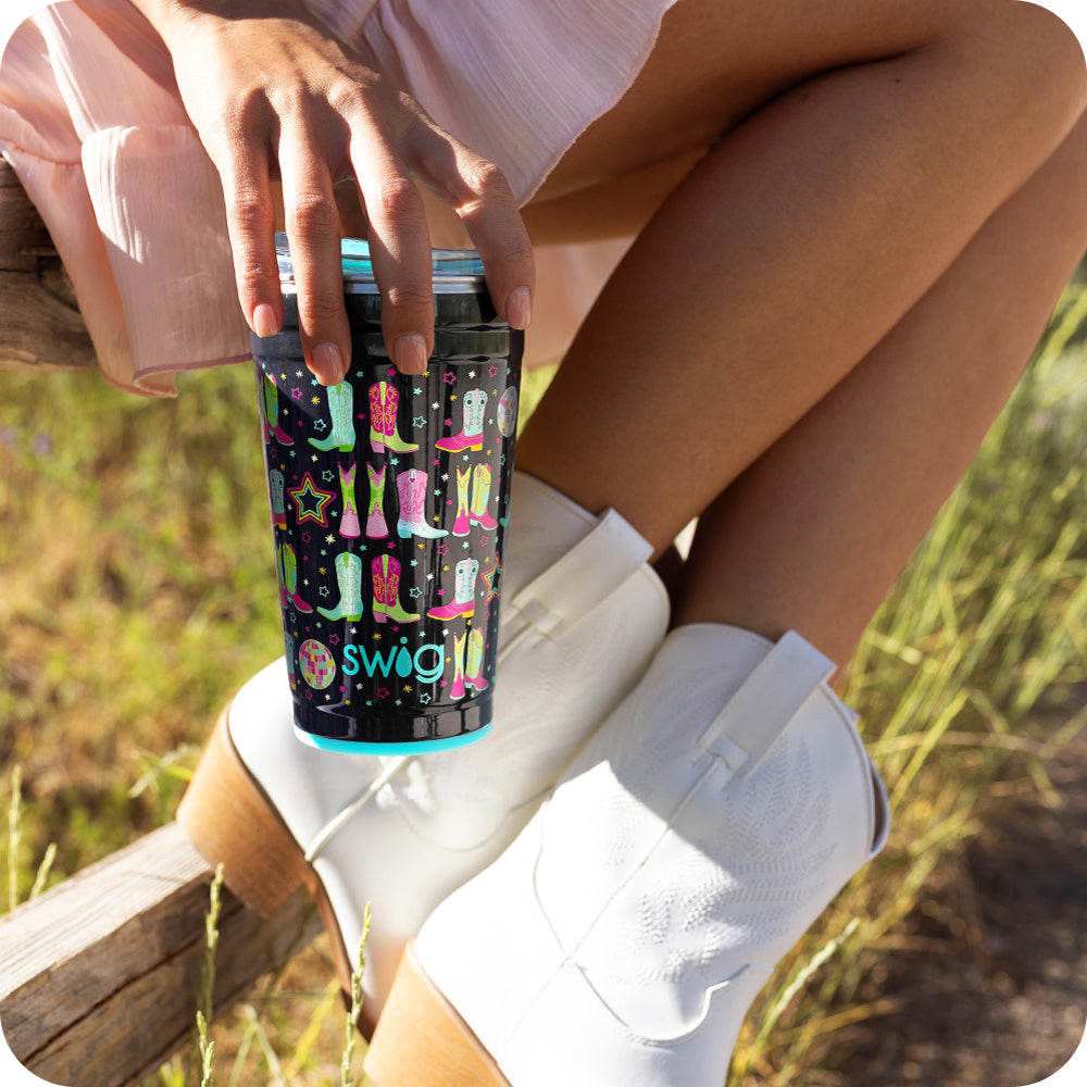 Swig Life 24oz Disco Cowgirl Insulated Party Cup being held by a women with cowboy boots