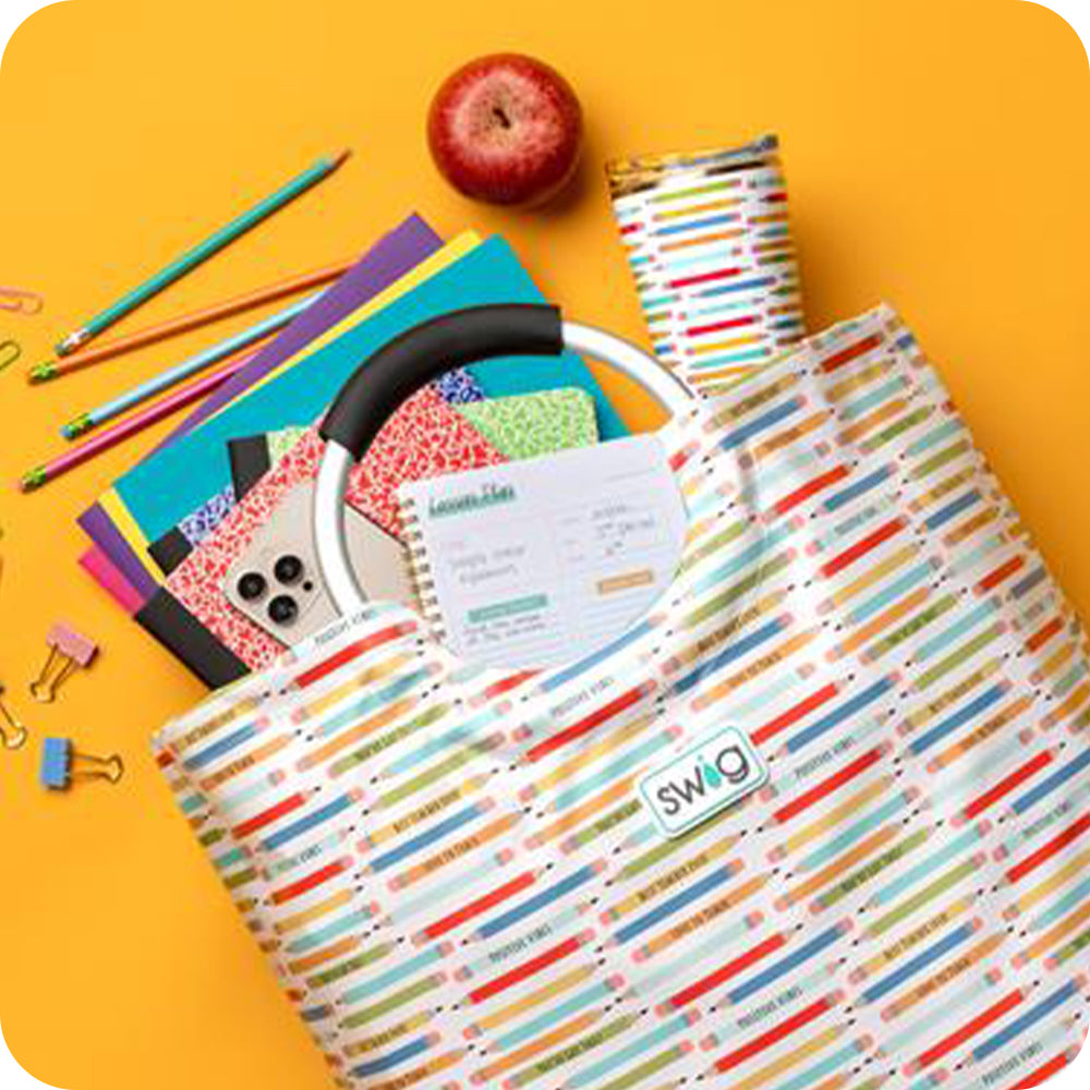 Swig Life Teacher Life Loopi spilled open with notebooks and pencils shot on a yellow background