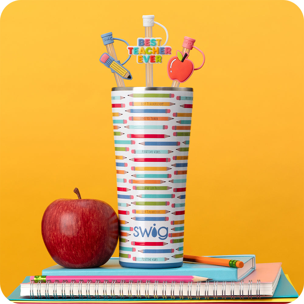 Swig Life Teacher Life 32oz Tumbler with Teacher Life Straw Topper Set shot on a yellow background with a red apple and a stack of notebooks and pencils