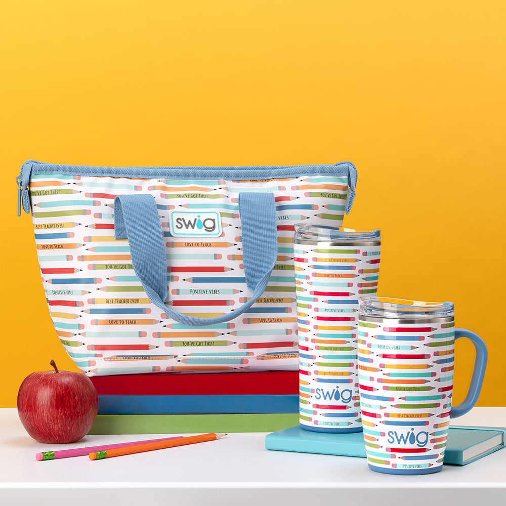 Swig Life Teacher Life Lunchi Lunch Bag with 22oz Tumbler and 18oz Travel Mug on a yellow background with a stack of books and a red apple