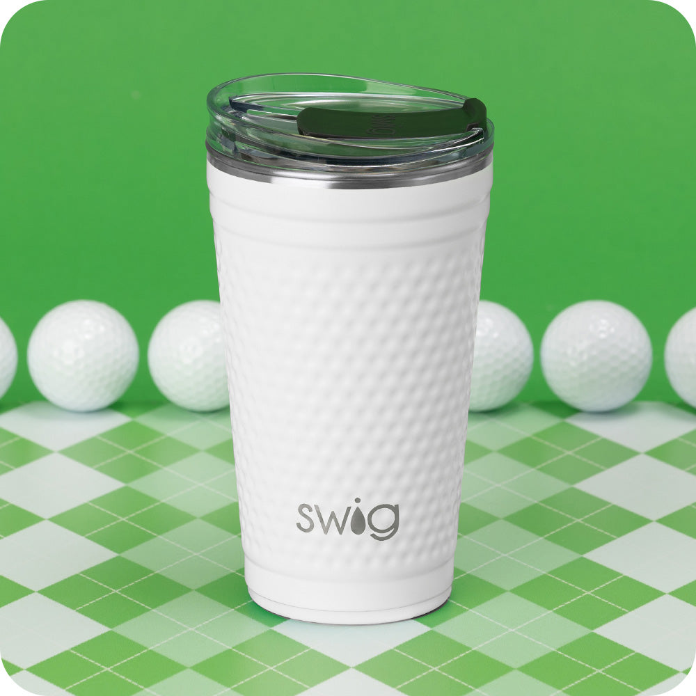 Swig Life 24oz Golf Insulated Party Cup surrounded by golf balls on a green background