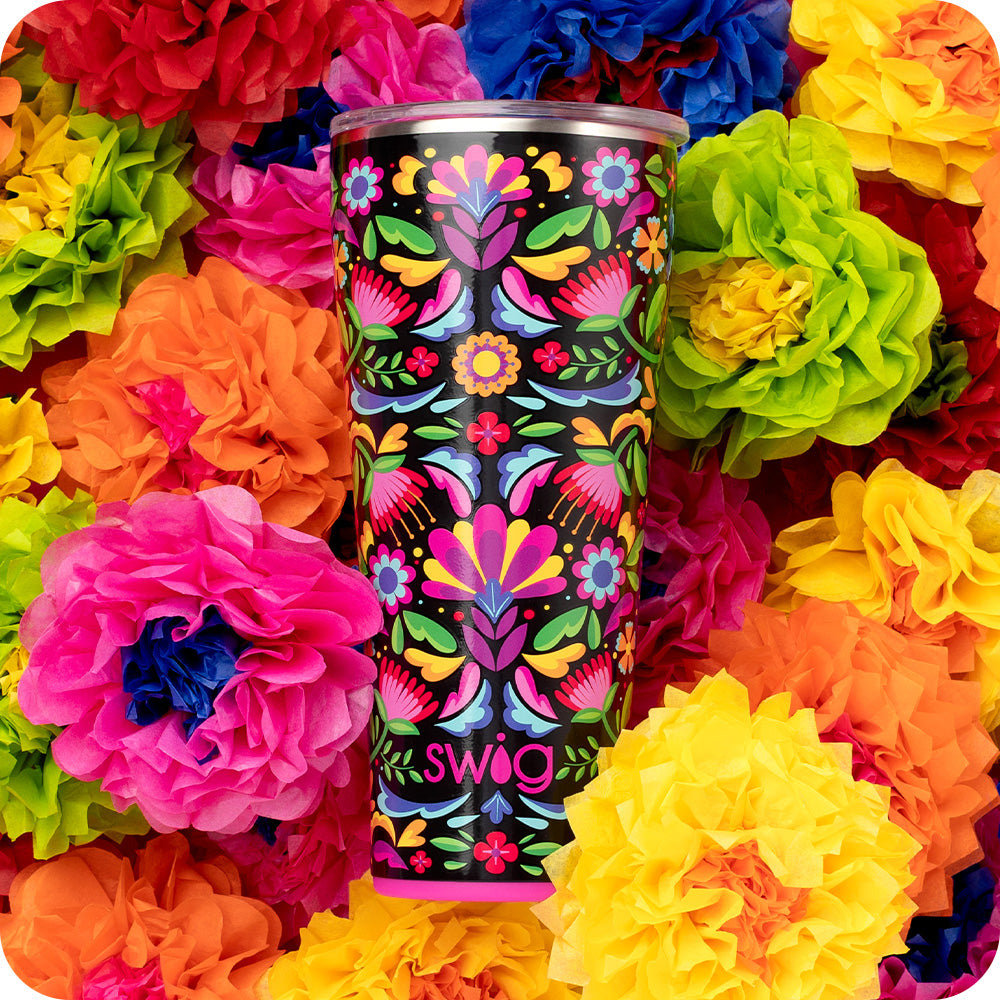 Swig Life 32oz Caliente Insulated Tumbler on a bed of colorful flowers