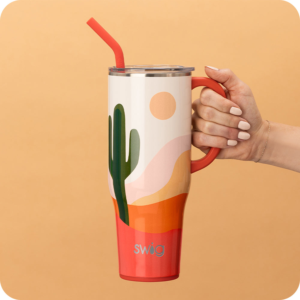Swig Life 40oz Boho Desert Insulated Mega Mug with lid and handle being held over an orange background