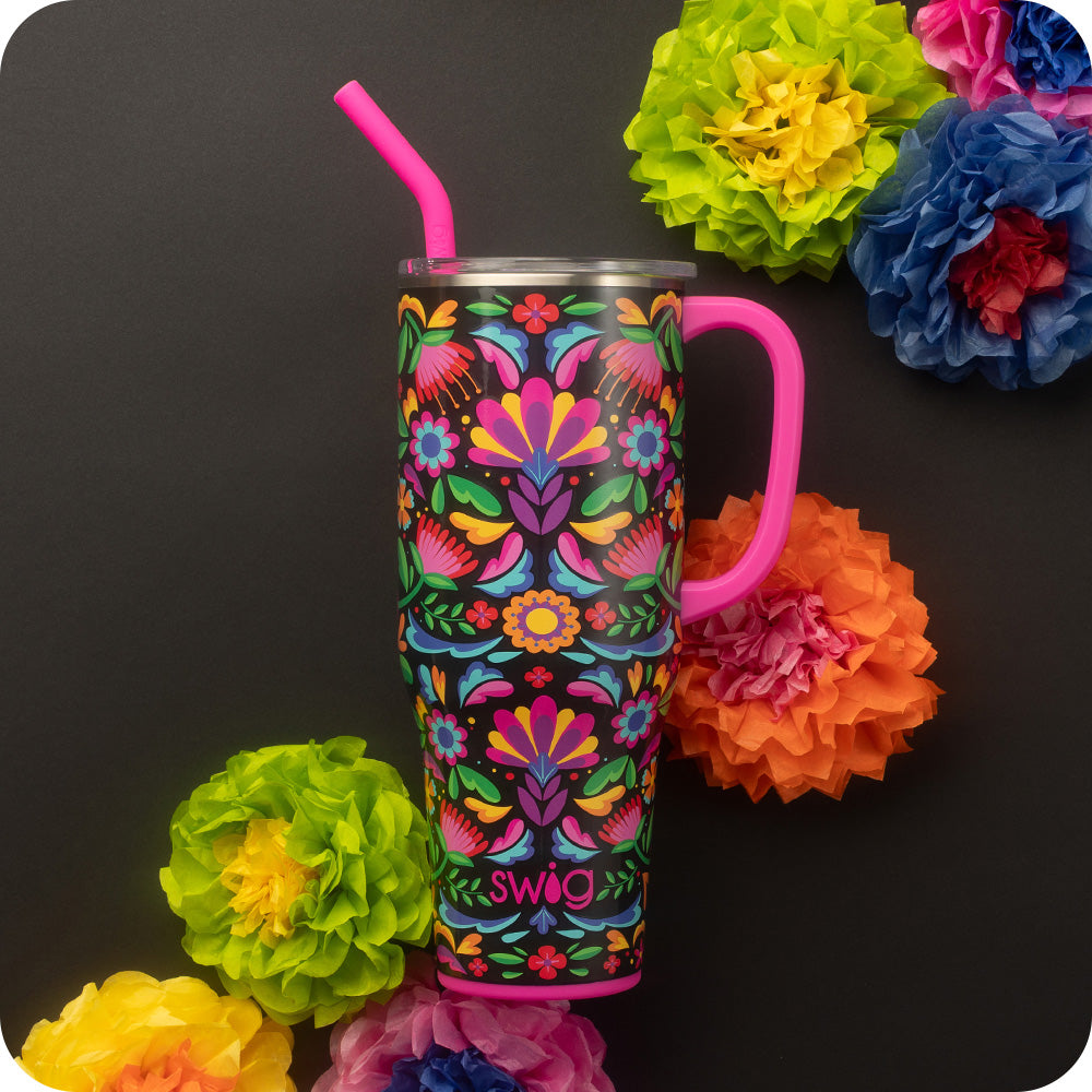 Swig Life 40oz Caliente Insulated Mega Mug with lid and handle surrounded by colorful flowers on a black background
