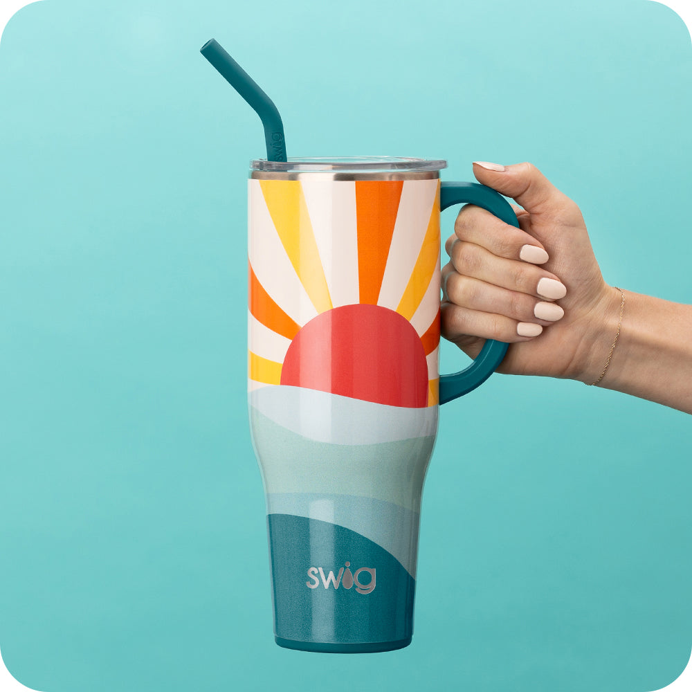 Swig Life 40oz Sun Dance Insulated Mega Mug being held over a blue background