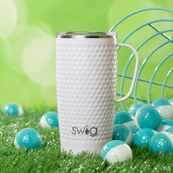 Swig Life 22oz Golf Partee Travel Mug on a green grassy background surrounded by golf balls