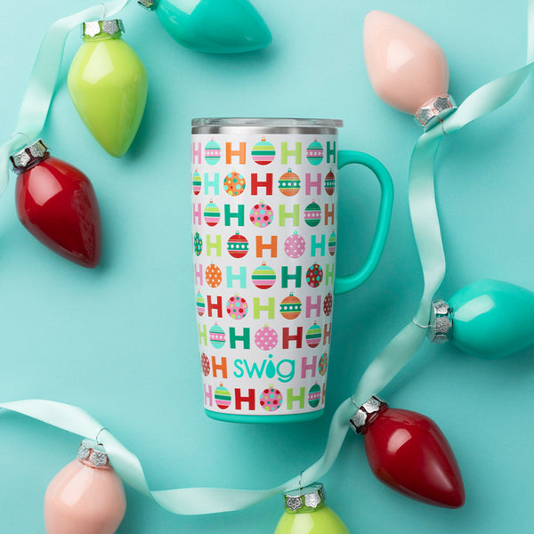 Swig Life 22oz Hohoho Travel Mug with string Holiday ornaments draped around it over a teal background