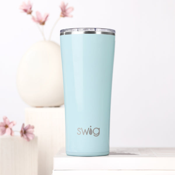 Swig Life 22oz Shimmer Aquamarine Insulated Tumbler on a white background with flowers