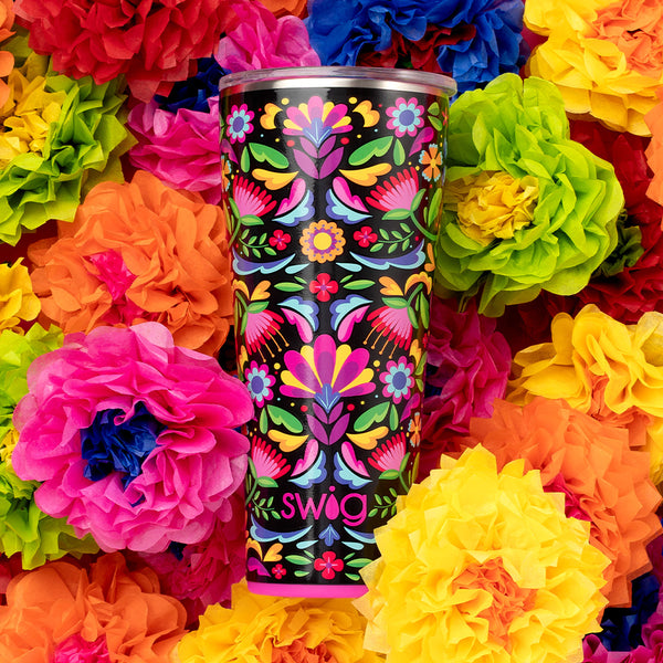 Swig Life 32oz Caliente Insulated Tumbler on a bed of colorful flowers