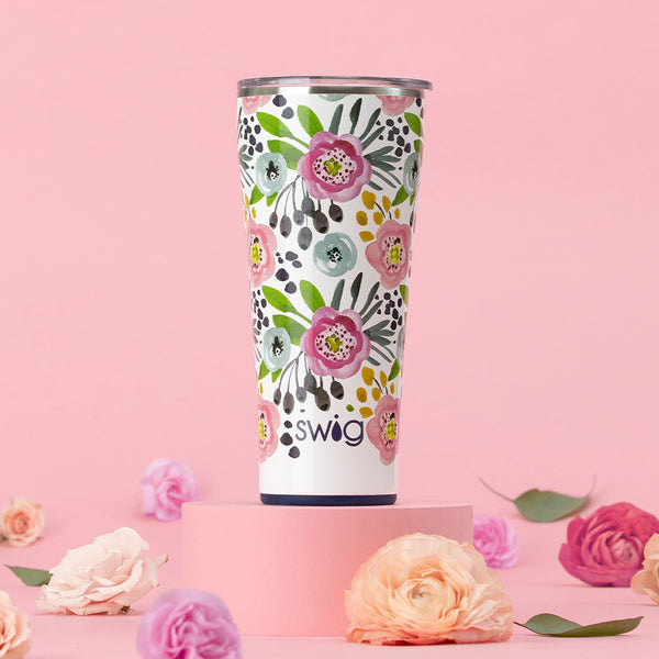 Swig Life 32oz Primrose Insulated Tumbler in a pink background surrounded by flowers