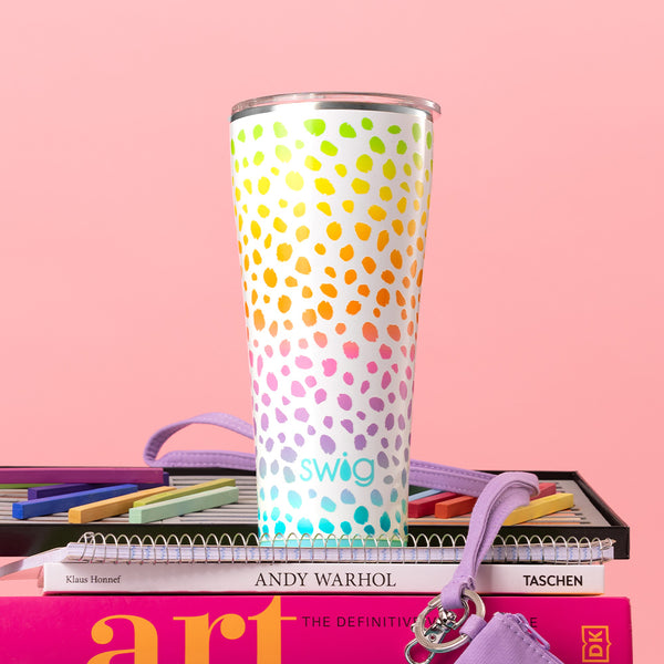 Swig Life 32oz Wild Child Insulated Tumbler on a stack of books