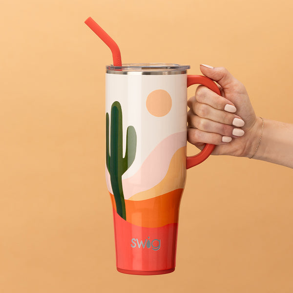Swig Life 40oz Boho Desert Insulated Mega Mug with lid and handle being held over an orange background
