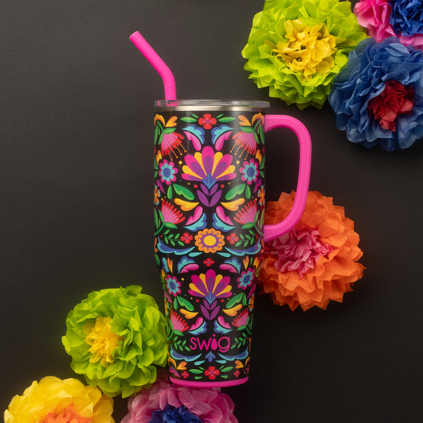 Swig Life 40oz Caliente Insulated Mega Mug with lid and handle surrounded by colorful flowers on a black background