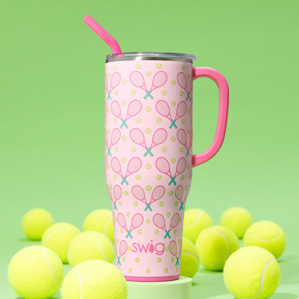 Swig Life 40oz Love All Insulated Mega Mug surrounded by tennis balls on a green background