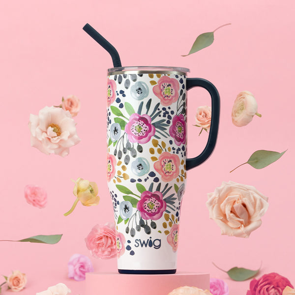 Swig Life 40oz Primrose Insulated Mega Mug with flowers a petals falling around it on a pink background