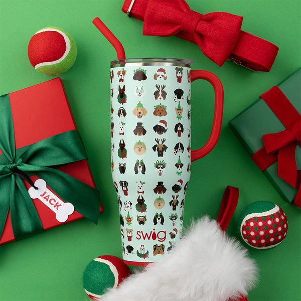 Swig Life 40oz Happy Howlidays Mega Mug surrounded by green and red wrapped gifts and a tennis ball over a green background