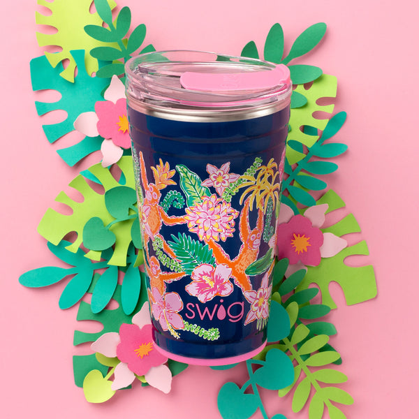 Swig Life 24oz Jungle Gym Insulated Party Cup on a pink background with paper leaves and tropical flowers