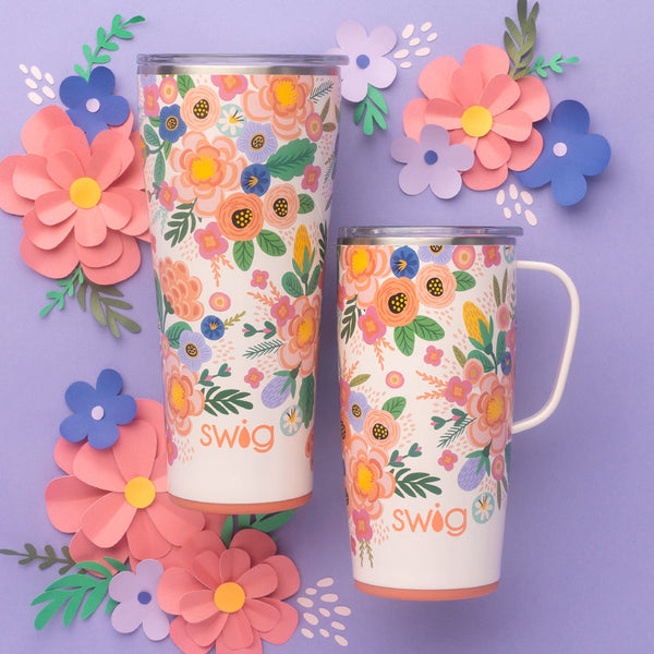 Swig Life Full Bloom 22oz Travel Mug and 32oz Tumbler with colorful paper flowers on a purple background
