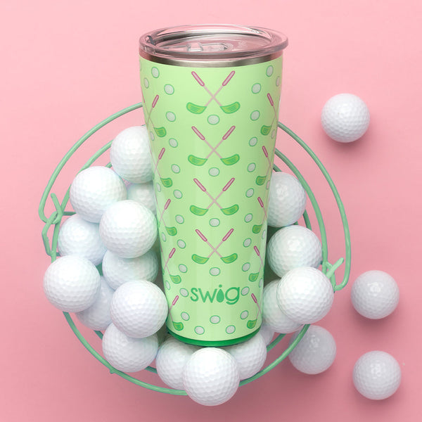 Swig Life Tee Time 32oz Tumblers in a basket with golf balls on a pink background