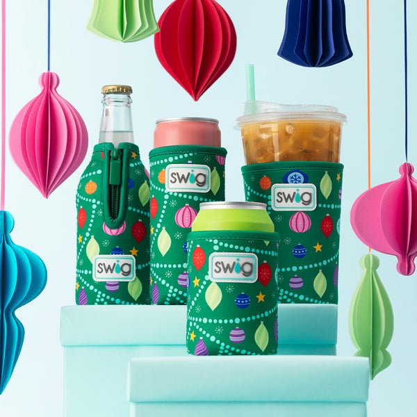 Swig Life O Christmas Tree Can Coolie with O Christmas Tree Bottle Coolie, Slim Can Coolie, and Iced Cup Coolie on a holiday background