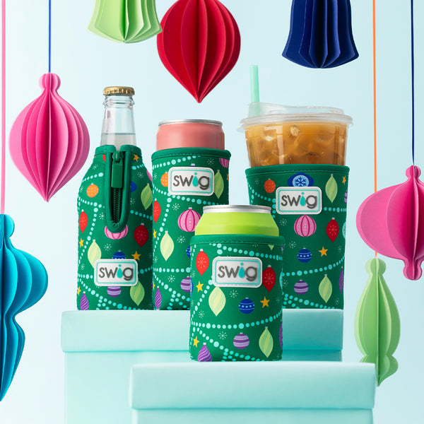 Swig Life O Christmas Tree Slim Can Coolie with O Christmas Tree Bottle Coolie, Can Coolie, and Iced Cup Coolie on a holiday background