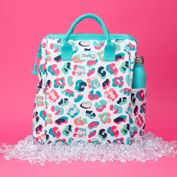 Swig Life Party Animal Packi Backpack Cooler sat on top of ice over a hot pink background