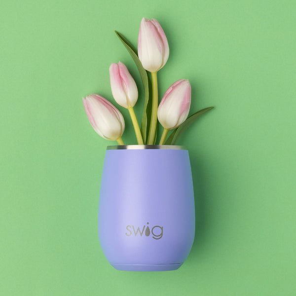 Swig Life 14oz Hydrangea Stemless Wine Cup on a green background with flowers coming out of the wine cup