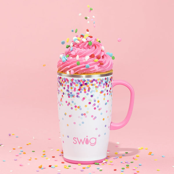 Swig Life 18oz Confetti Travel Mug topped with icing and sprinkles on a pink background