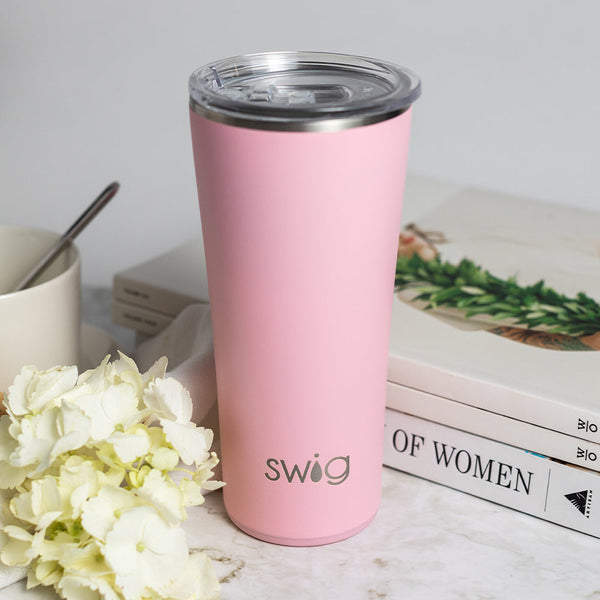 Swig Life 22oz Blush Insulated Tumbler on a marble counter with books
