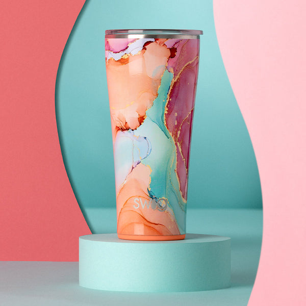 Swig Life 32oz Dreamsicle Tumbler on a teal and pink abstract background