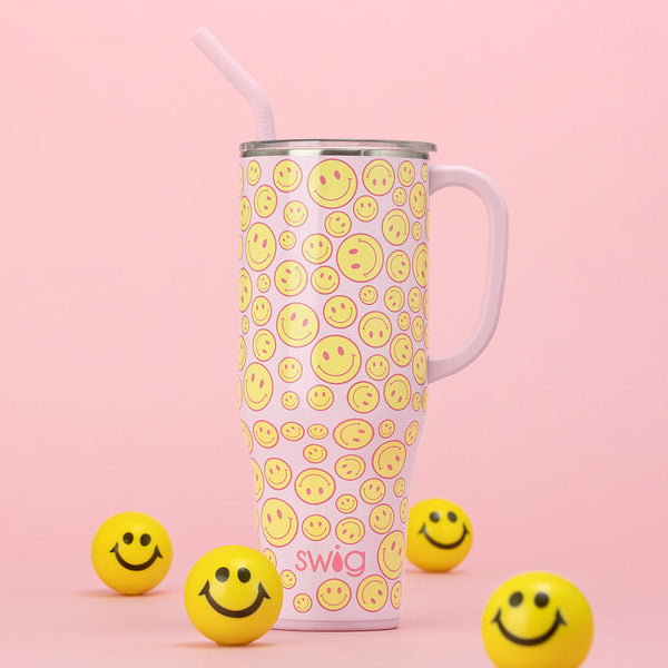 Swig Life 40oz Oh Happy Day Mega Mug shown on a pink background next to small yellow smiley face balls